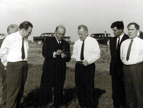 Six men standing in the field.
