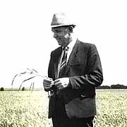 Ivan Ovcharenko wearing a white hat and a suit in the field.