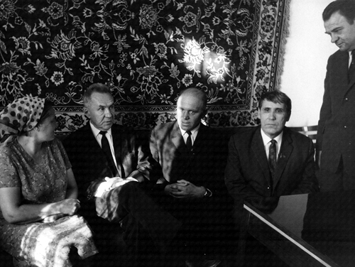 A group of four men and one woman in a room